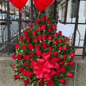 Arreglo floral con rosas rojas y globos con helio